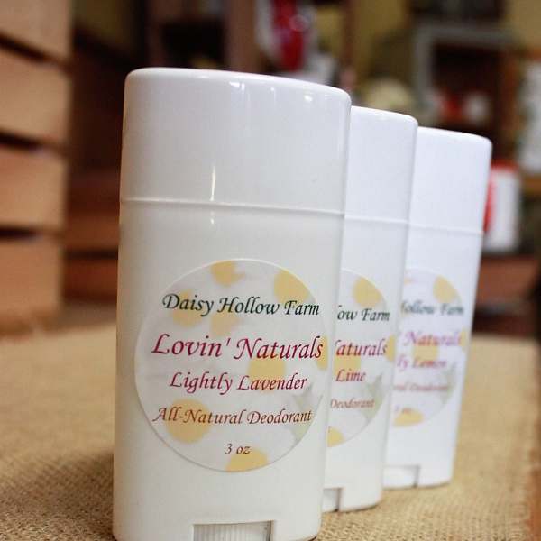 Three white deodorant sticks with lavender labels on a burlap surface