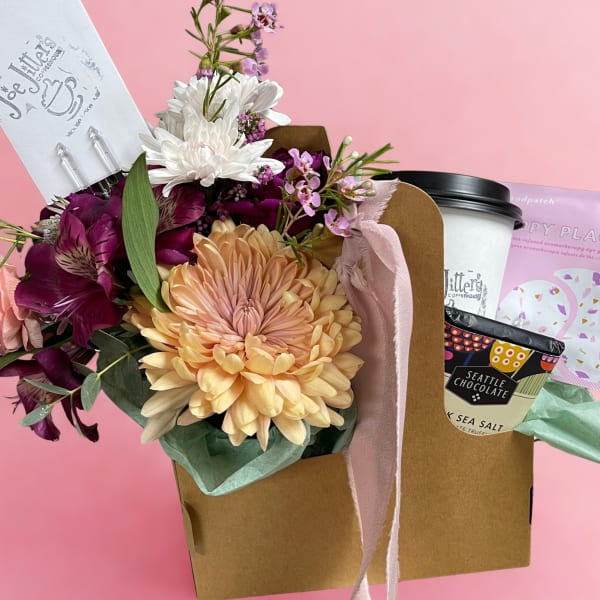 Bouquet with peach and purple flowers beside a gift box and chocolate cup