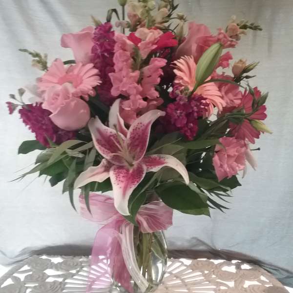 Pink mixed bouquet with lilies and roses in a glass vase