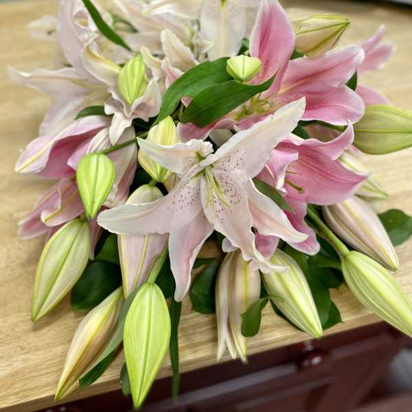 Pink and white lilies arranged in a bouquet on a table