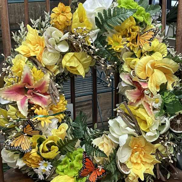 Yellow and white floral wreath with butterflies and greenery