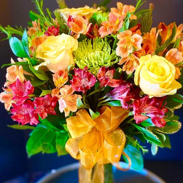 Bouquet of yellow roses and pink alstroemeria with a gold ribbon
