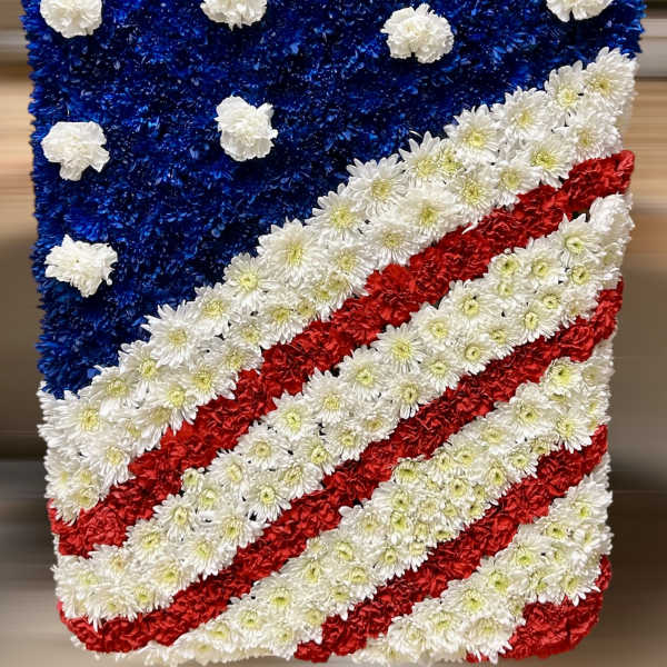 Rectangular floral American flag arrangement with blue, red, and white flowers.