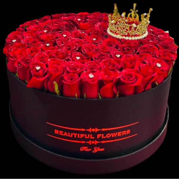 Round box of red roses topped with a gold crown