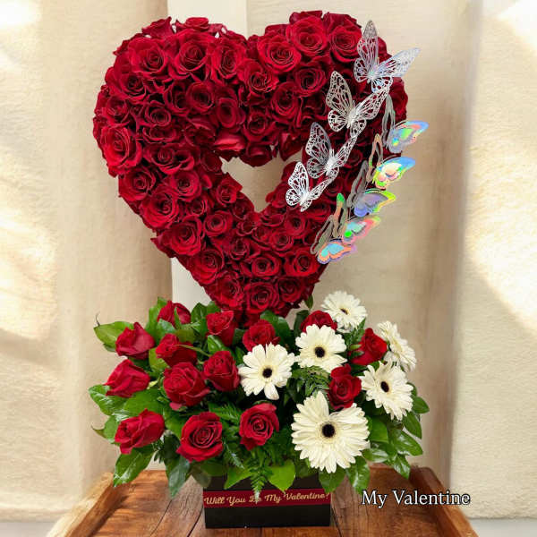 Heart-shaped red rose arrangement with white daisies and butterfly accents