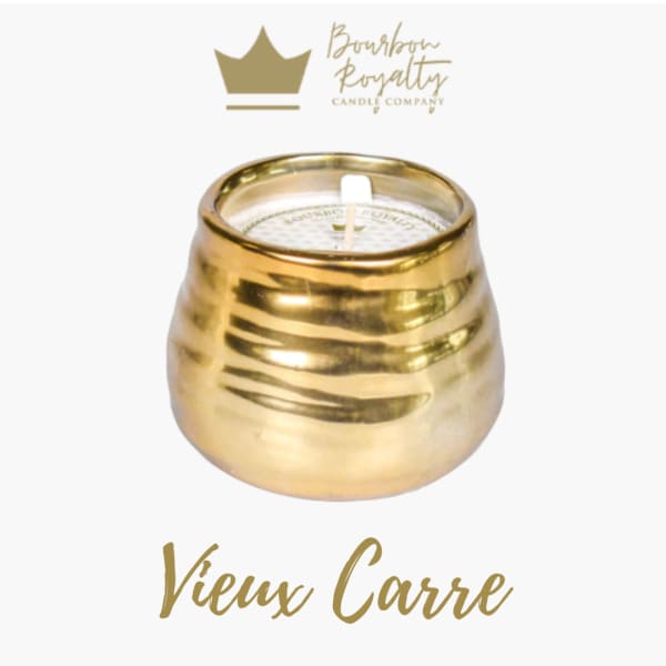 Gold candle in a rounded metallic holder with a white wick