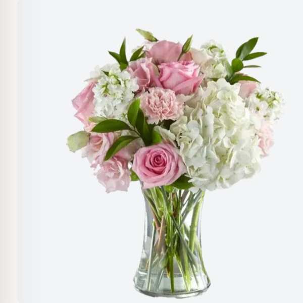 Pink roses and white hydrangeas in a clear glass vase