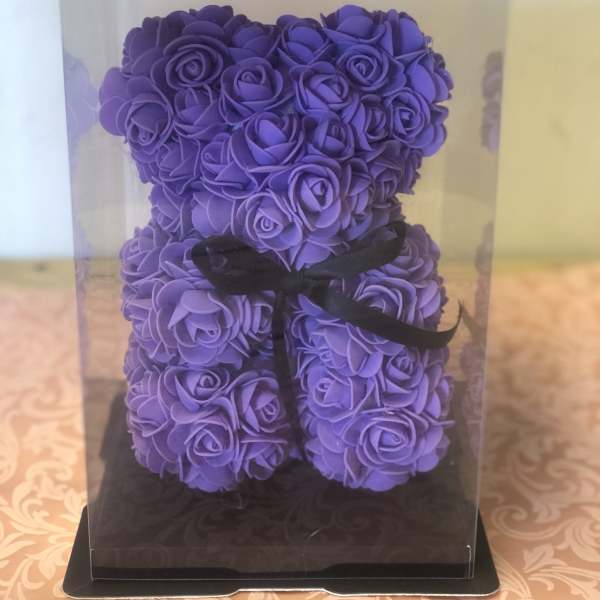 Purple rose-shaped teddy bear in a clear gift box with a black ribbon