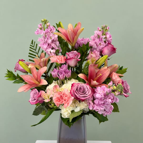 Pink and lavender mixed bouquet in a tall gray vase