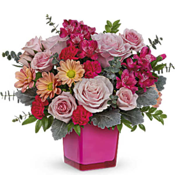 Pink and peach flower arrangement in a magenta vase
