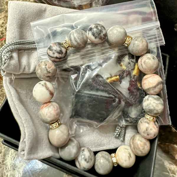 Beaded bracelet and a heart-shaped item in plastic packaging