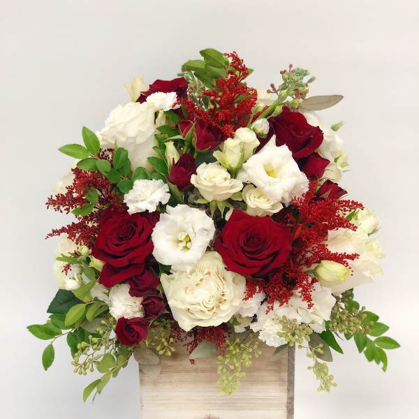 Red and white rose arrangement in a wooden box