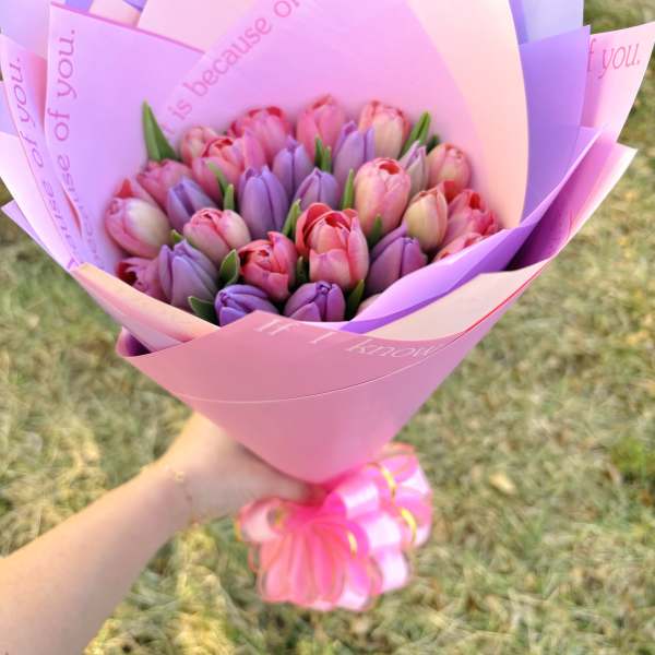 Bouquet of pink and purple tulips wrapped in pastel paper