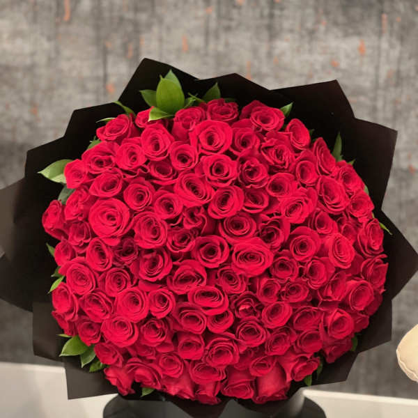 Large bouquet of red roses wrapped in black paper