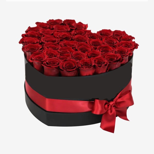 Heart-shaped box of red roses with a red satin ribbon