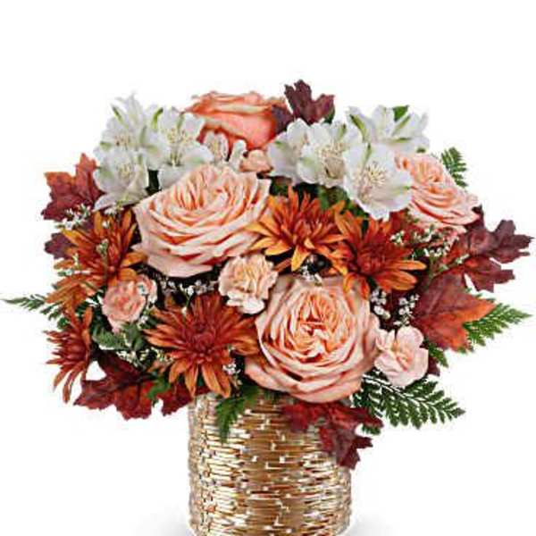 Bouquet of peach roses and white flowers in a woven vase