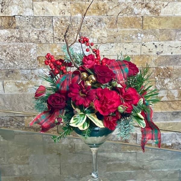 Red floral arrangement in a wine glass vase with plaid ribbon