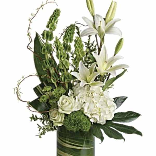 White lilies and roses arranged in a green glass vase