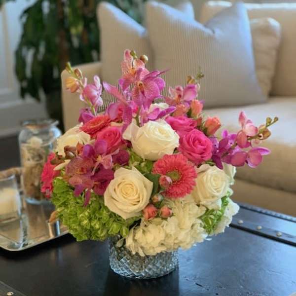 Pink and white rose bouquet with orchids in a glass vase