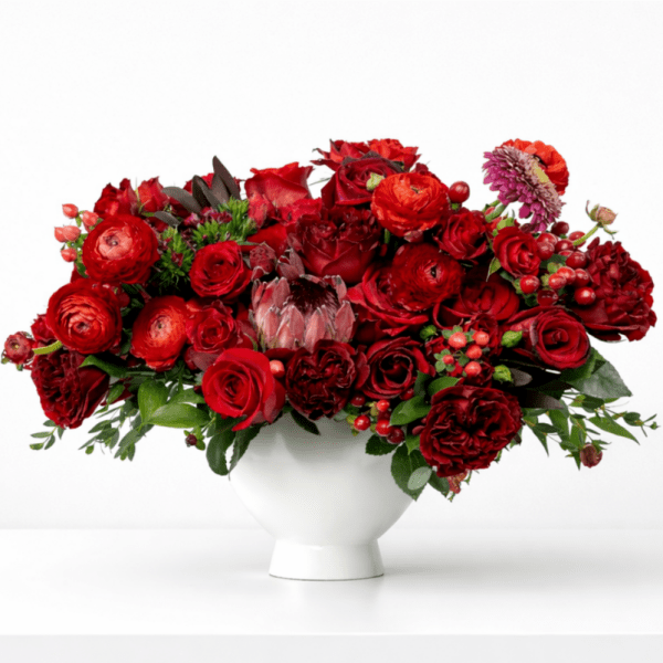 Red rose arrangement in a white vase