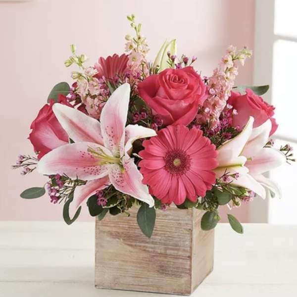 Pink roses, lilies, and gerbera daisies in a wooden box