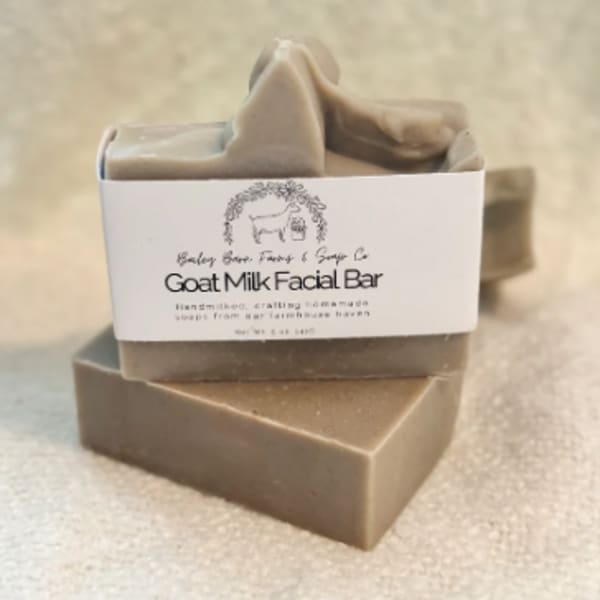 Stacked goat milk soap bars with a label on top