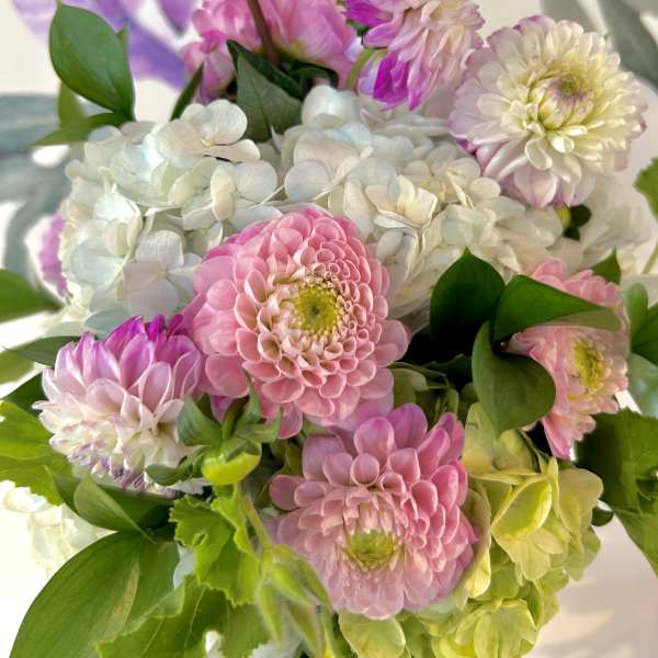Pink and white flowers arranged with green foliage
