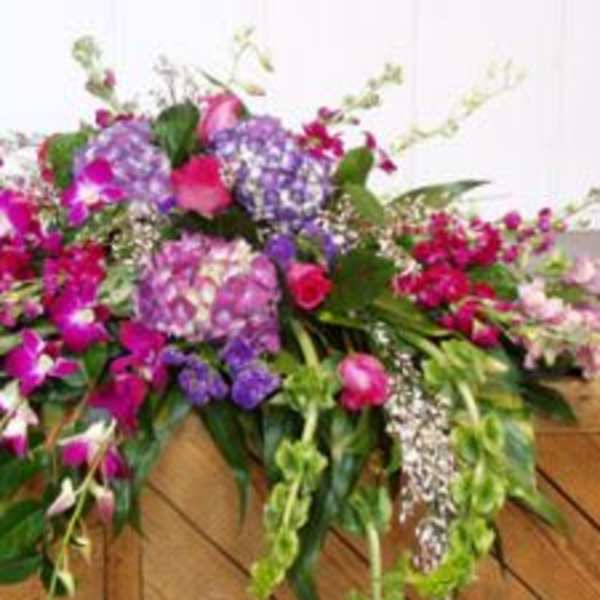 Large pink and purple floral arrangement with cascading blooms