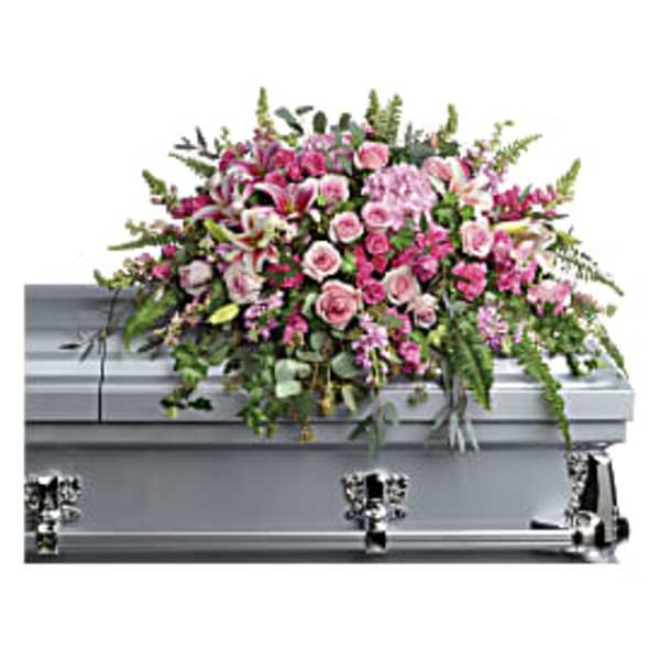 Pink and white casket spray with roses and lilies on a silver casket