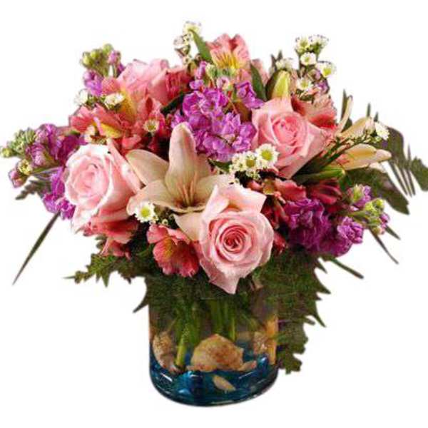 Pink roses and mixed blooms arranged in a blue glass vase