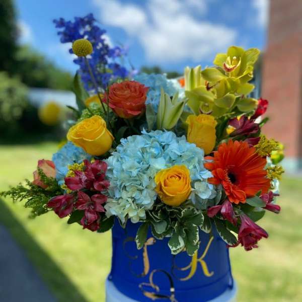 Colorful mixed bouquet in a blue container outdoors