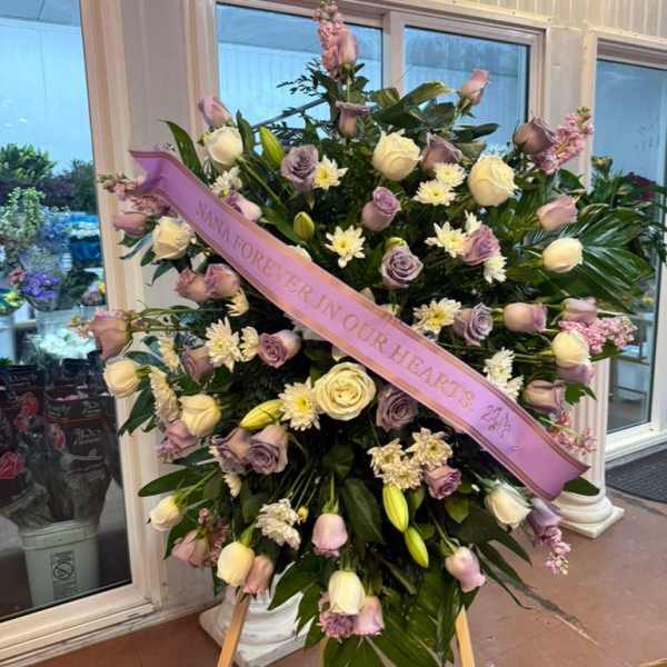 Large standing floral spray with a pink memorial ribbon