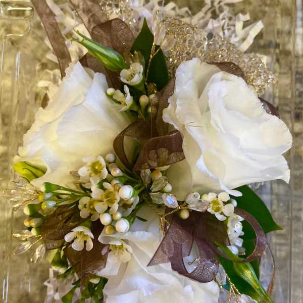 White floral bouquet with brown ribbon and decorative packaging
