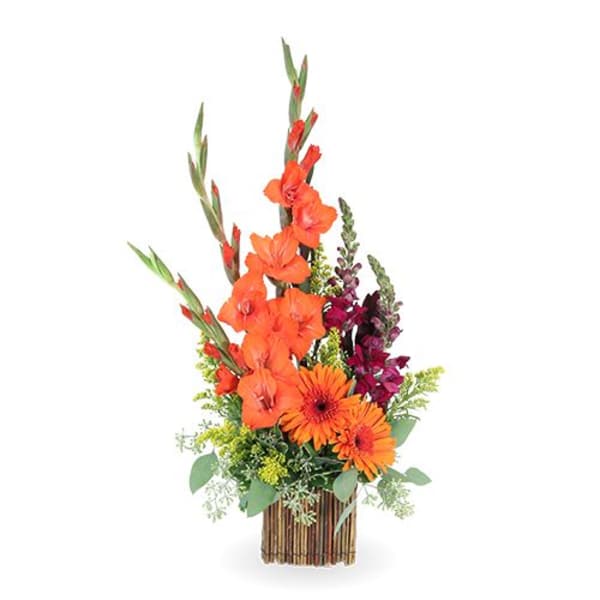 Tall orange and burgundy floral arrangement in a striped vase