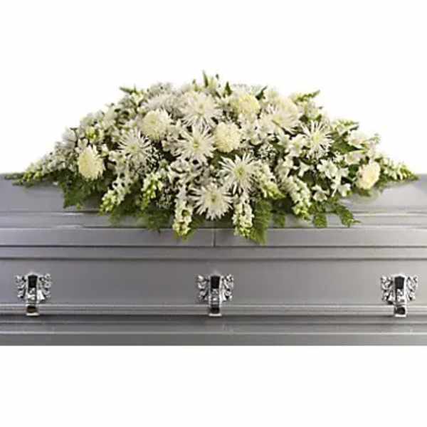 White floral casket spray with a silver casket