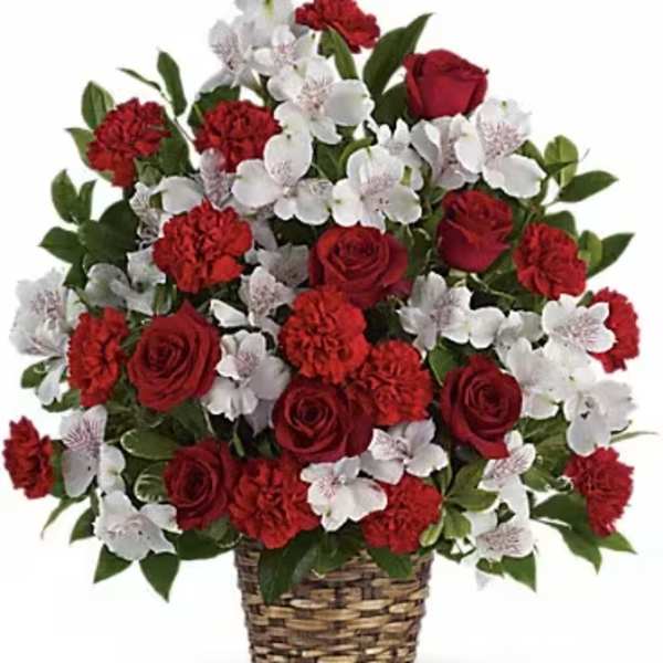 Red roses and white flowers arranged in a woven basket