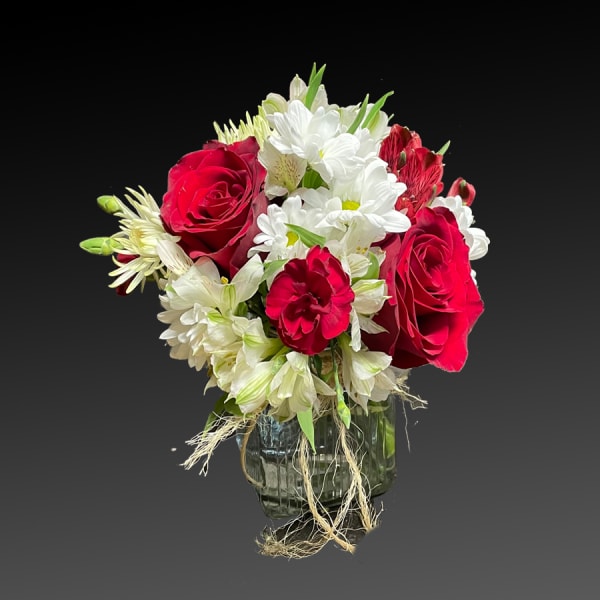 Red roses and white daisies in a glass vase