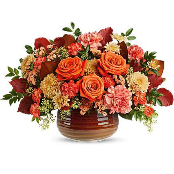 Orange roses and pink carnations in a brown glass vase