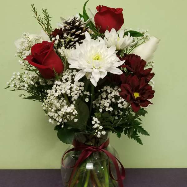 Bouquet of red roses, white chrysanthemums, and baby's breath in a glass vase