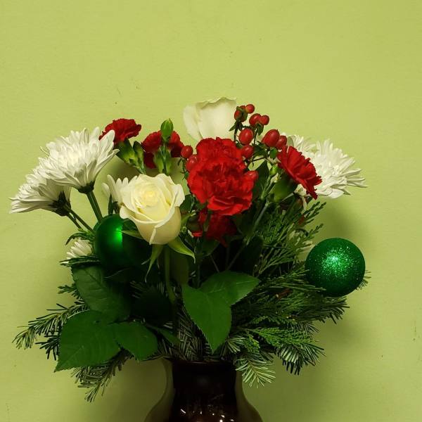 Red and white flowers arranged in a dark vase with green ornaments