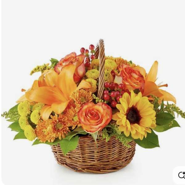 Basket of orange and yellow flowers with roses and lilies