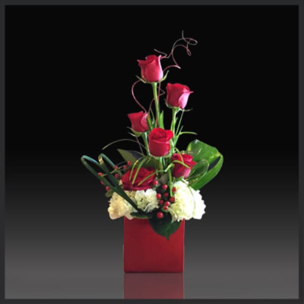 Tall red rose arrangement in a red square vase