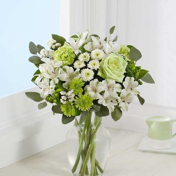 Green and white bouquet in a clear glass vase