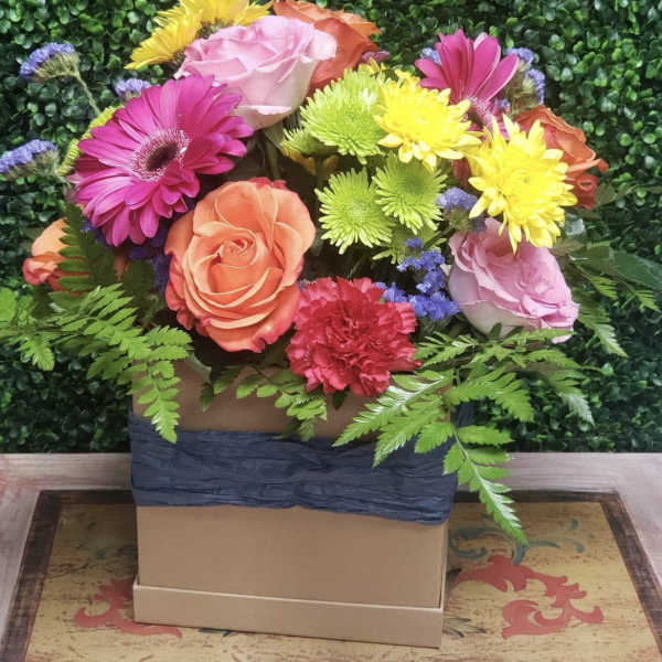 Colorful mixed bouquet in a square box with roses, gerberas, and mums