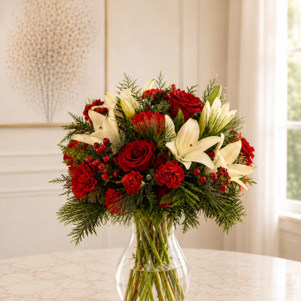 Red roses and white lilies arranged in a clear glass vase