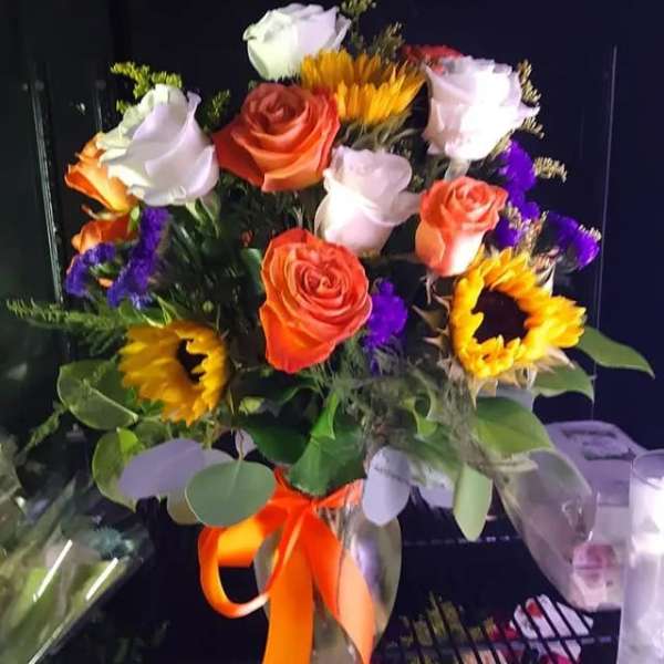 Bouquet of orange and white roses with sunflowers and purple filler