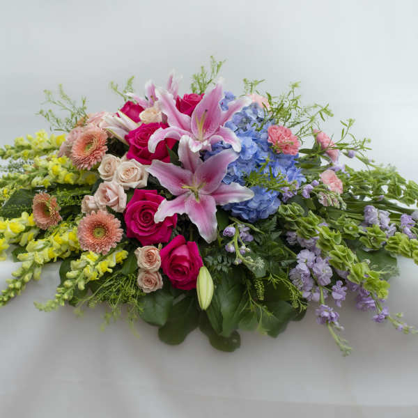Low floral spray with pink lilies, roses, hydrangeas, and yellow blooms