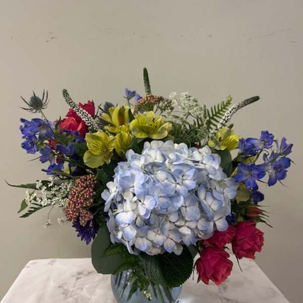 Mixed bouquet with blue hydrangea in a glass vase