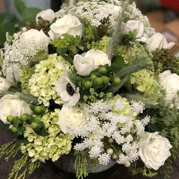 White roses and pale green hydrangeas in a round bouquet
