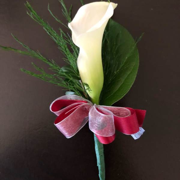 White calla lily boutonniere with red ribbon bow